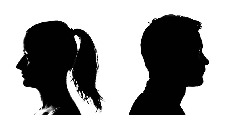 Silhouette of man and woman facing away from each other